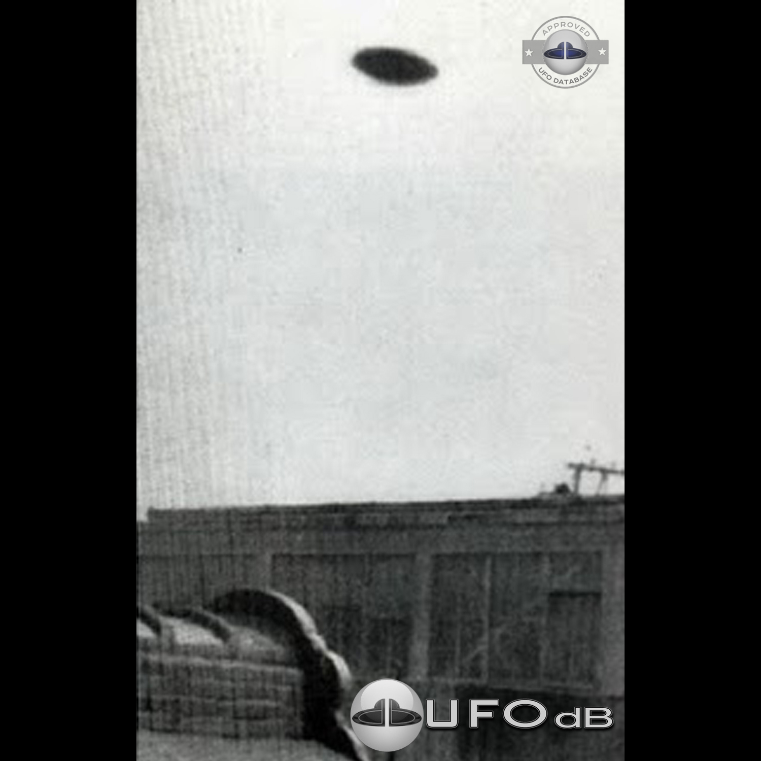 Saucer shaped UFO passing over buildings in Kaizuka on a cloudy day UFO Picture #128-1