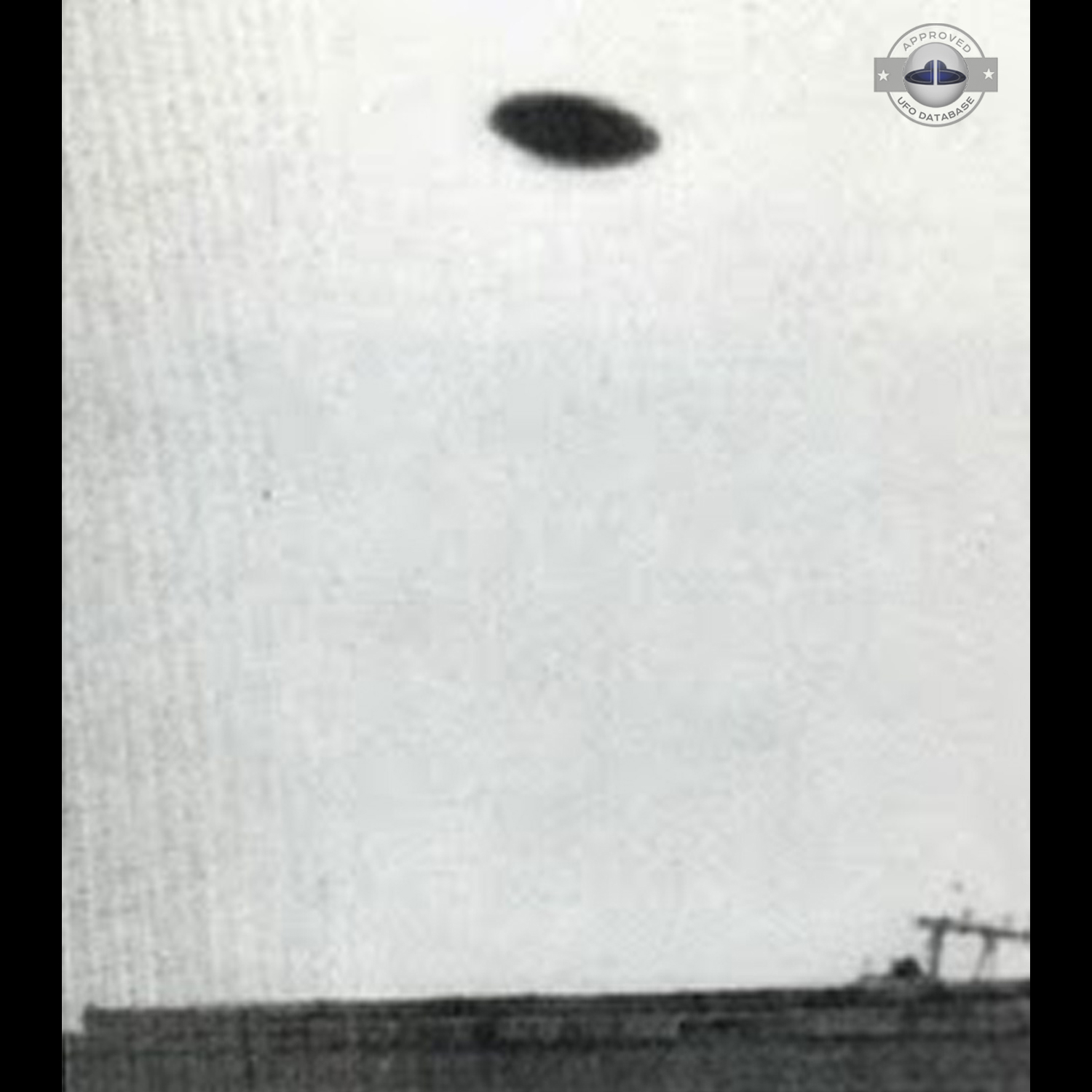 Saucer shaped UFO passing over buildings in Kaizuka on a cloudy day UFO Picture #128-2