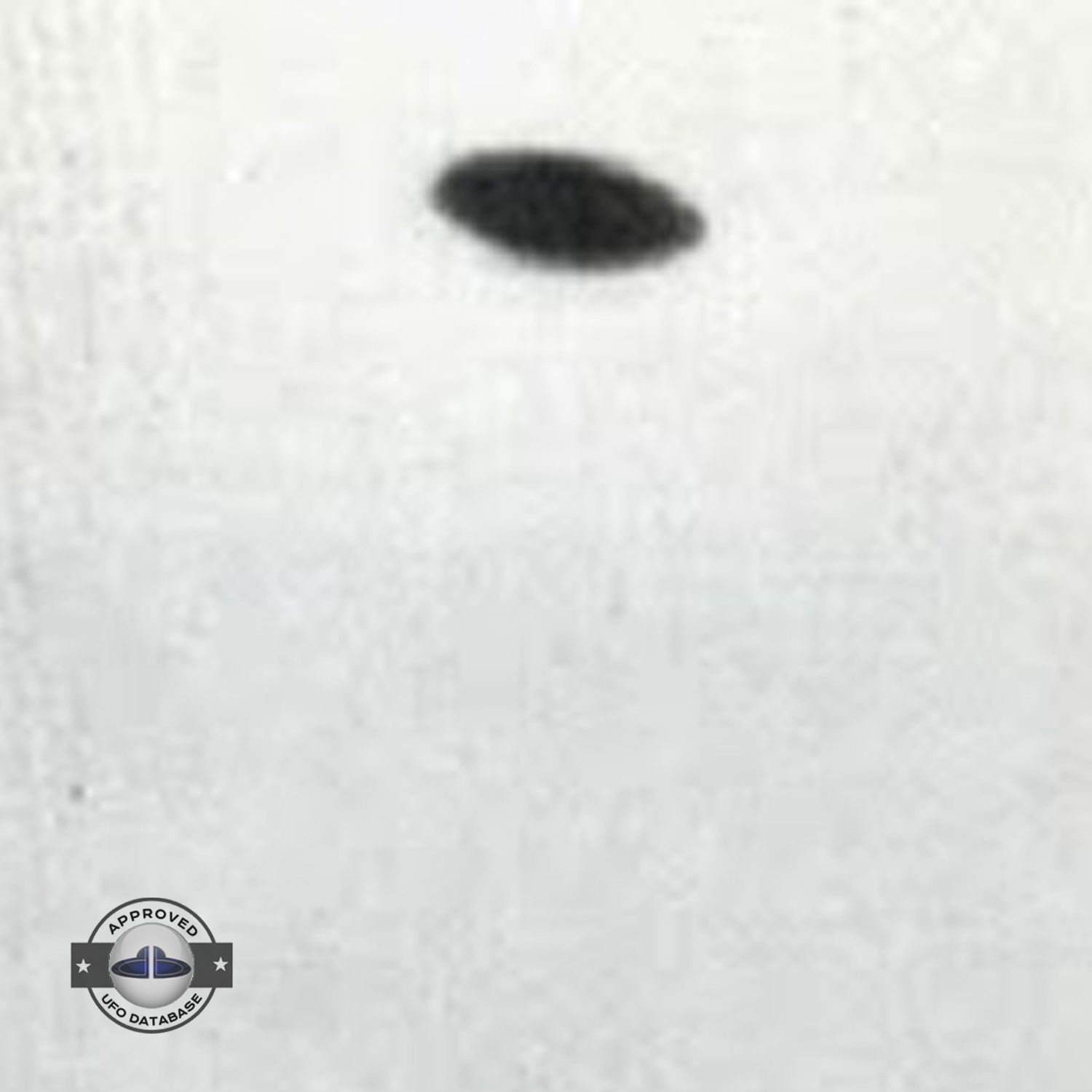 Saucer shaped UFO passing over buildings in Kaizuka on a cloudy day UFO Picture #128-3