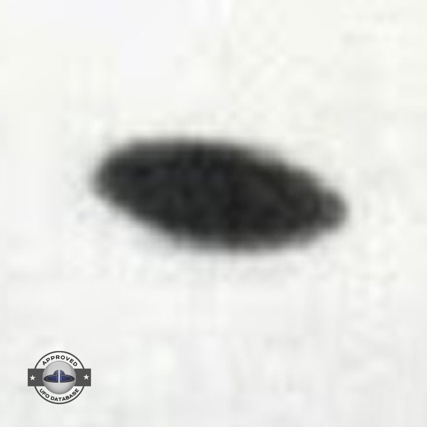 Saucer shaped UFO passing over buildings in Kaizuka on a cloudy day UFO Picture #128-4