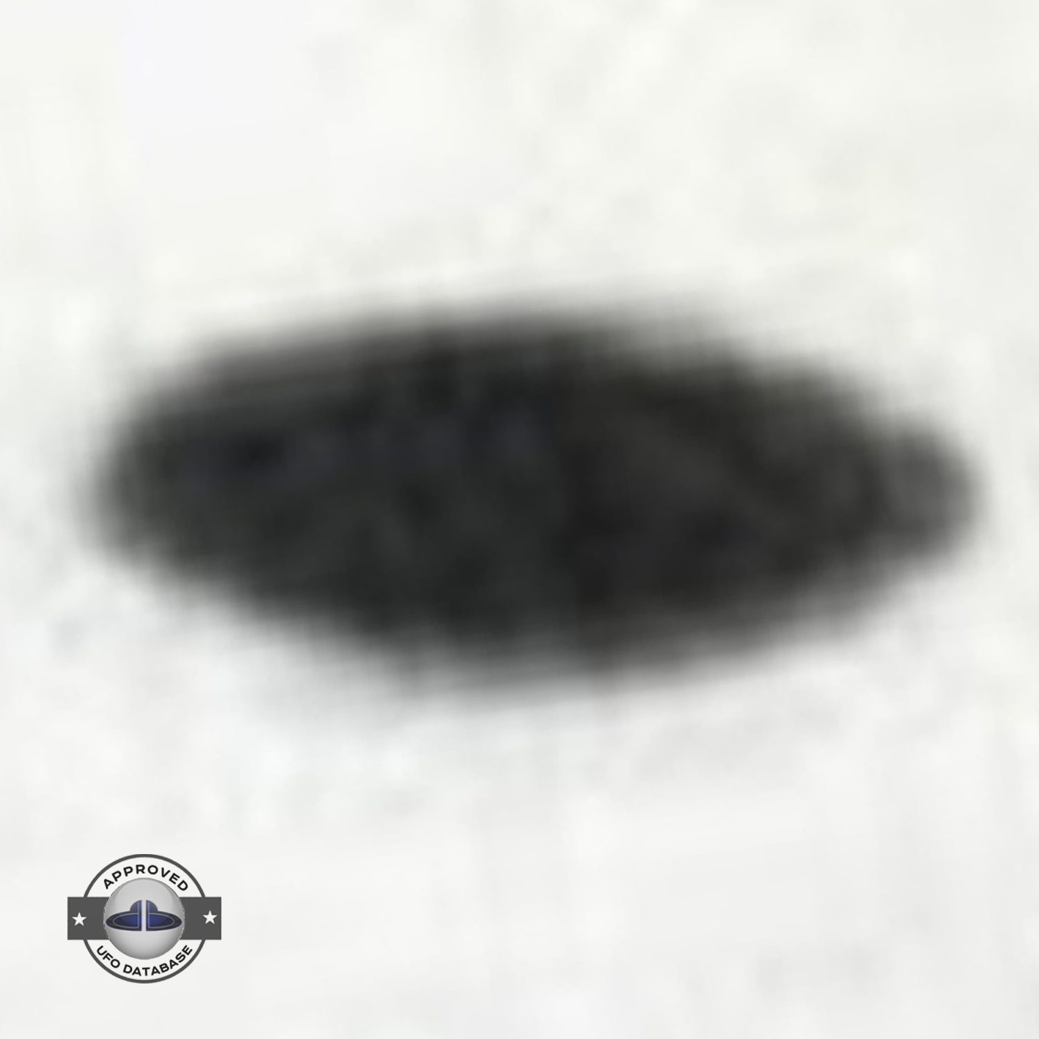 Saucer shaped UFO passing over buildings in Kaizuka on a cloudy day UFO Picture #128-5