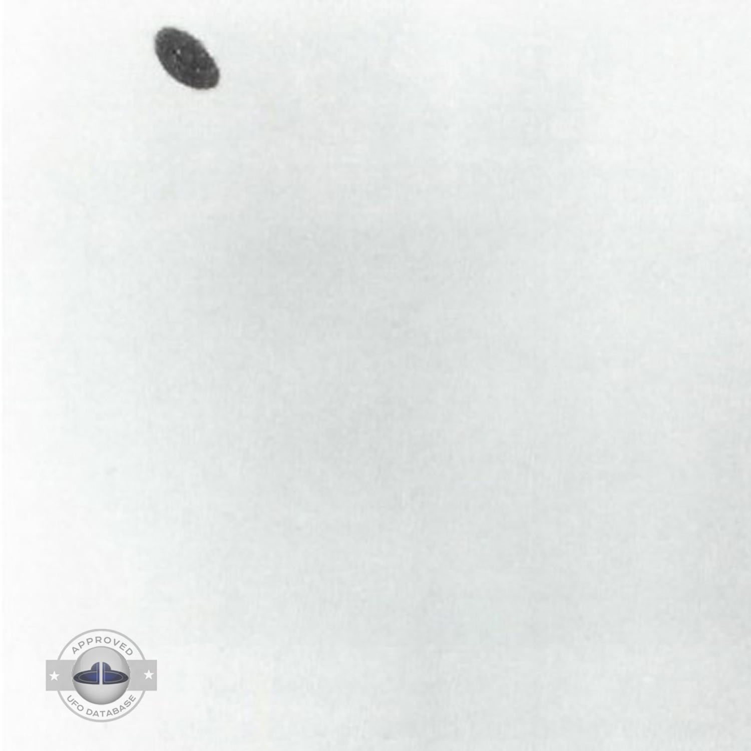 Grey UFO picture UFO high in the sky over buildings and mountains UFO Picture #106-2