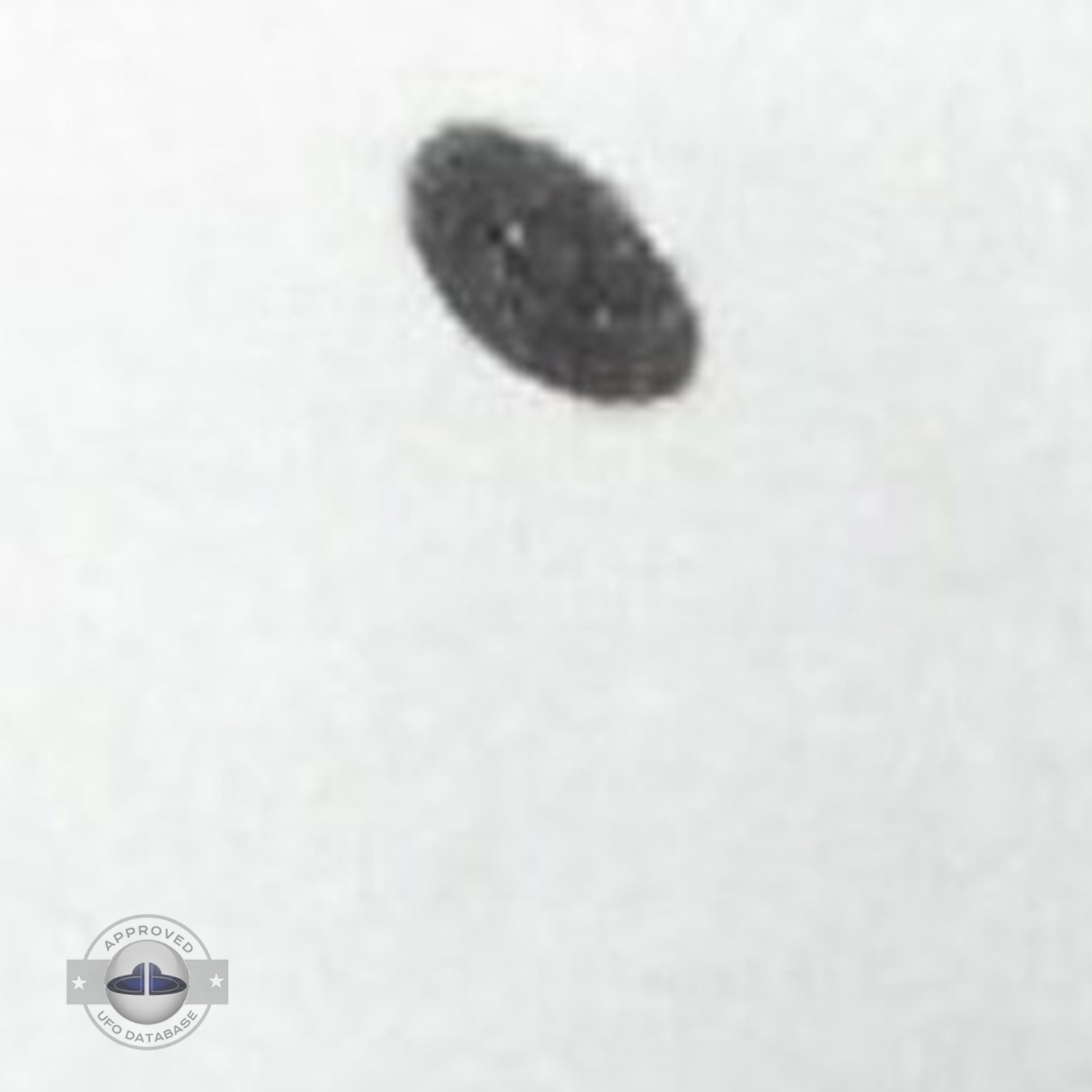 Grey UFO picture UFO high in the sky over buildings and mountains UFO Picture #106-3