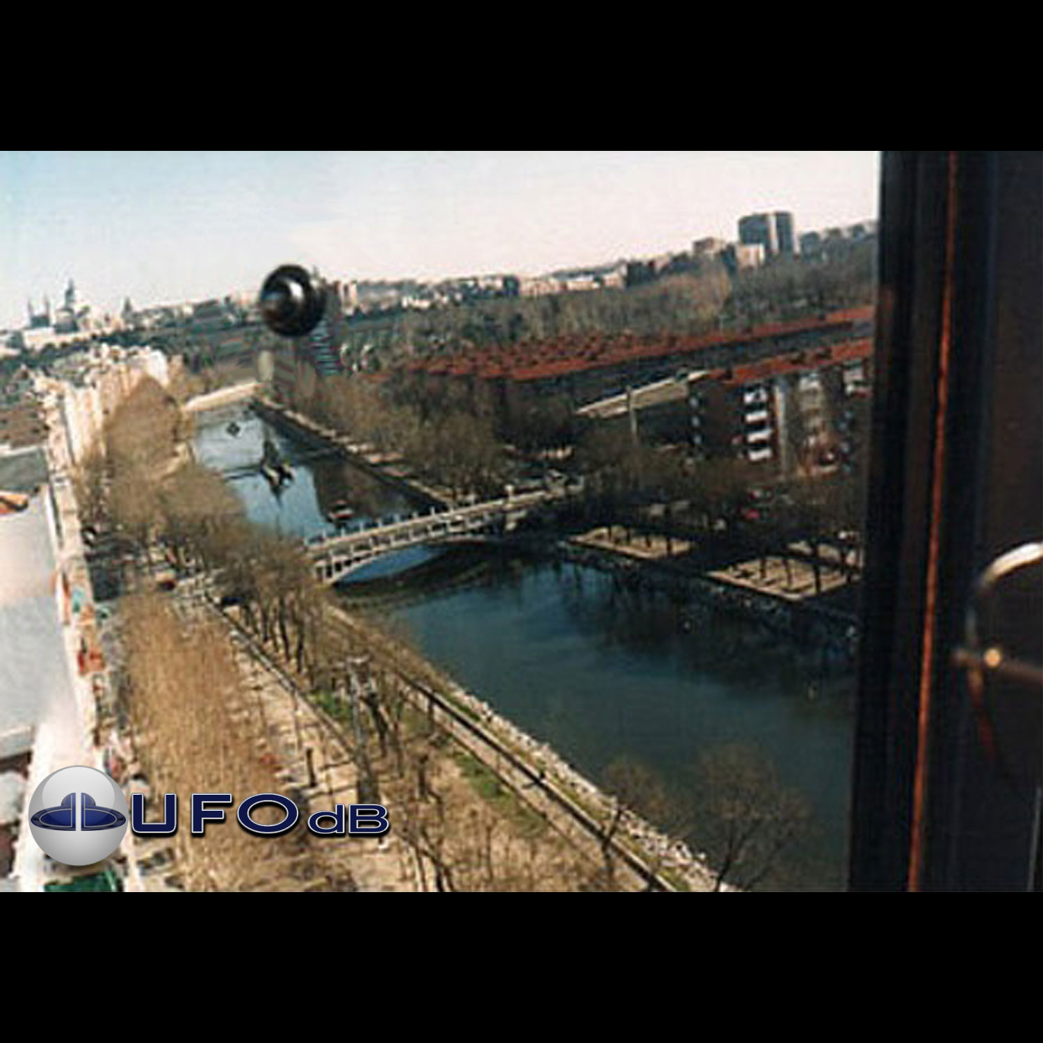 In bright day light over a water canal in the middle of Madrid UFO Picture #42-1