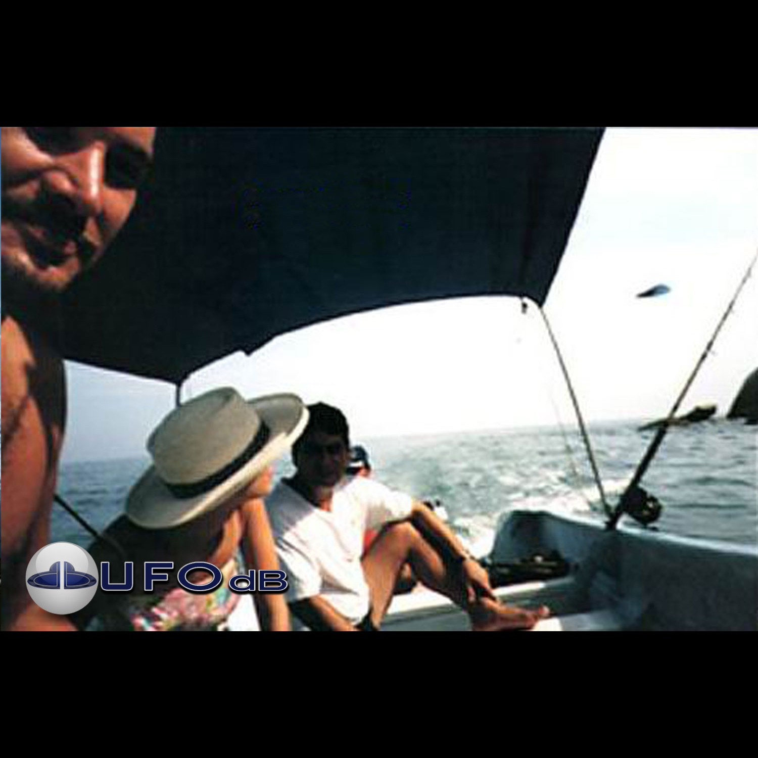 we can see people in a small boat, and behind them a UFO passing UFO Picture #40-1