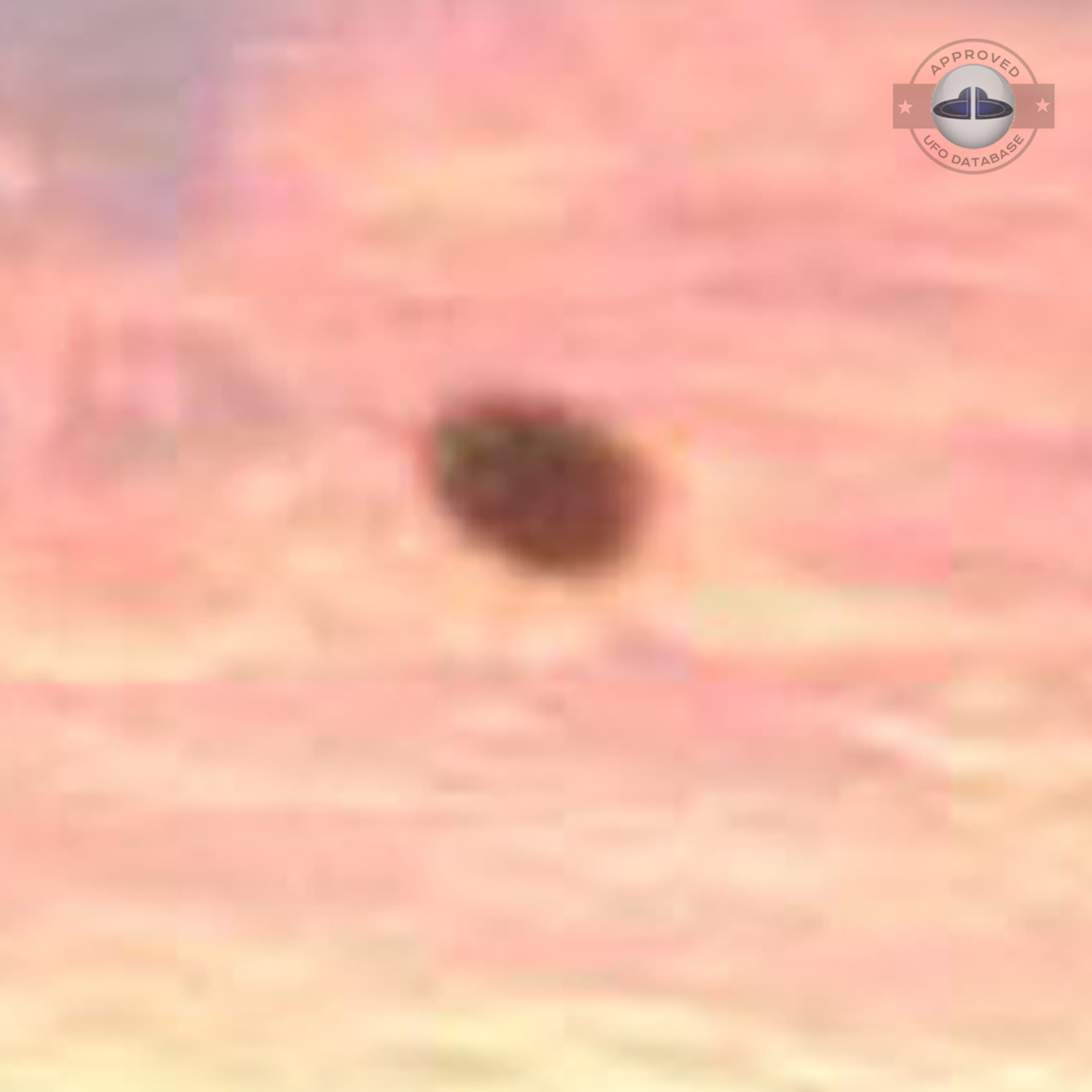 The UFO came out from a light in the cloudy sky during sunset UFO Picture #76-5