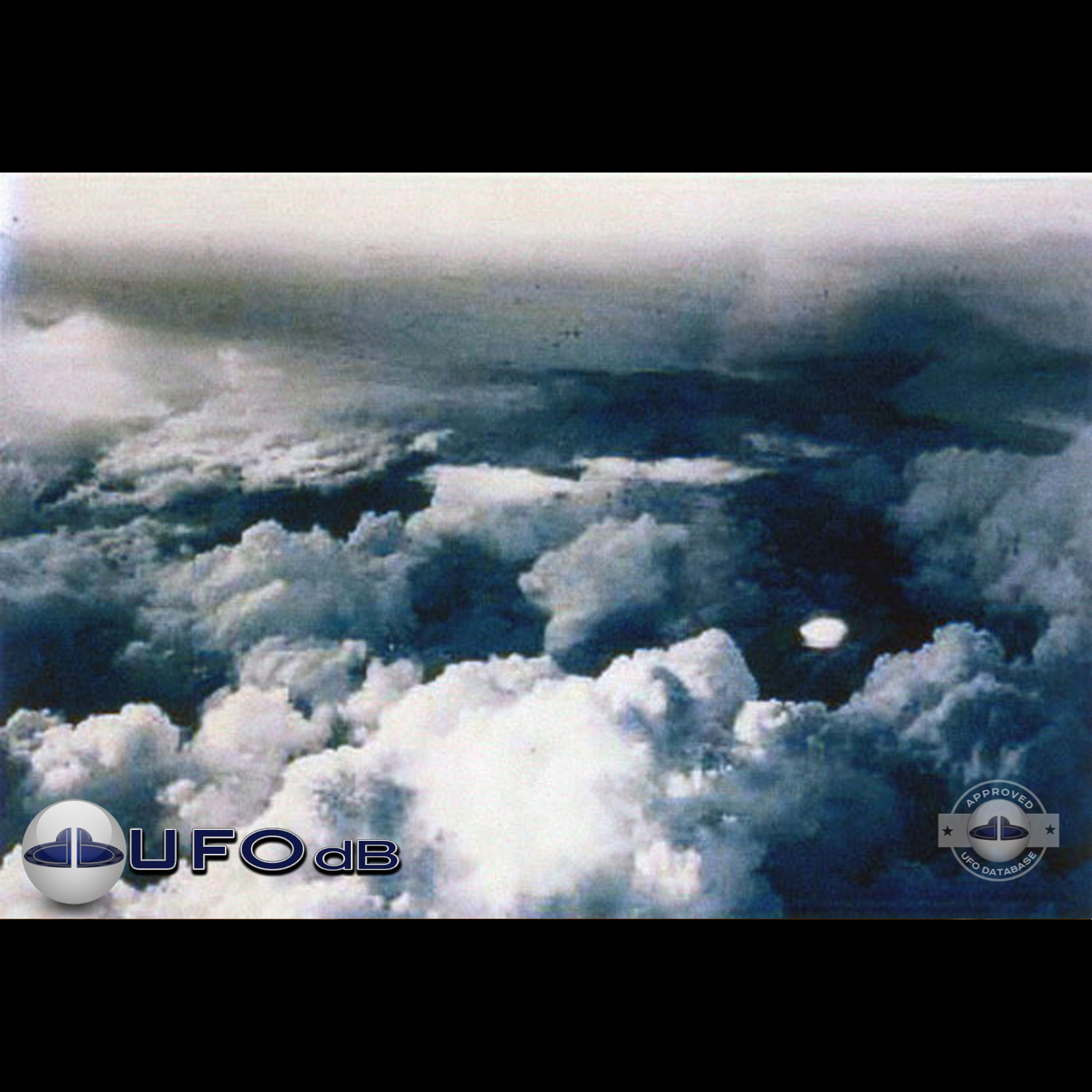 very bright disc-like object remaining stationary near a thunderhead UFO Picture #102-1