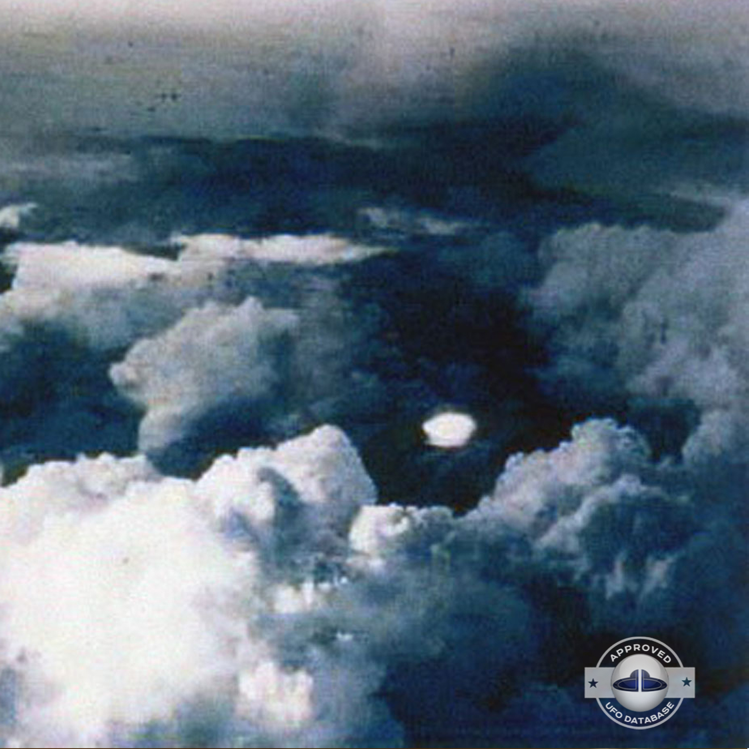 very bright disc-like object remaining stationary near a thunderhead UFO Picture #102-2