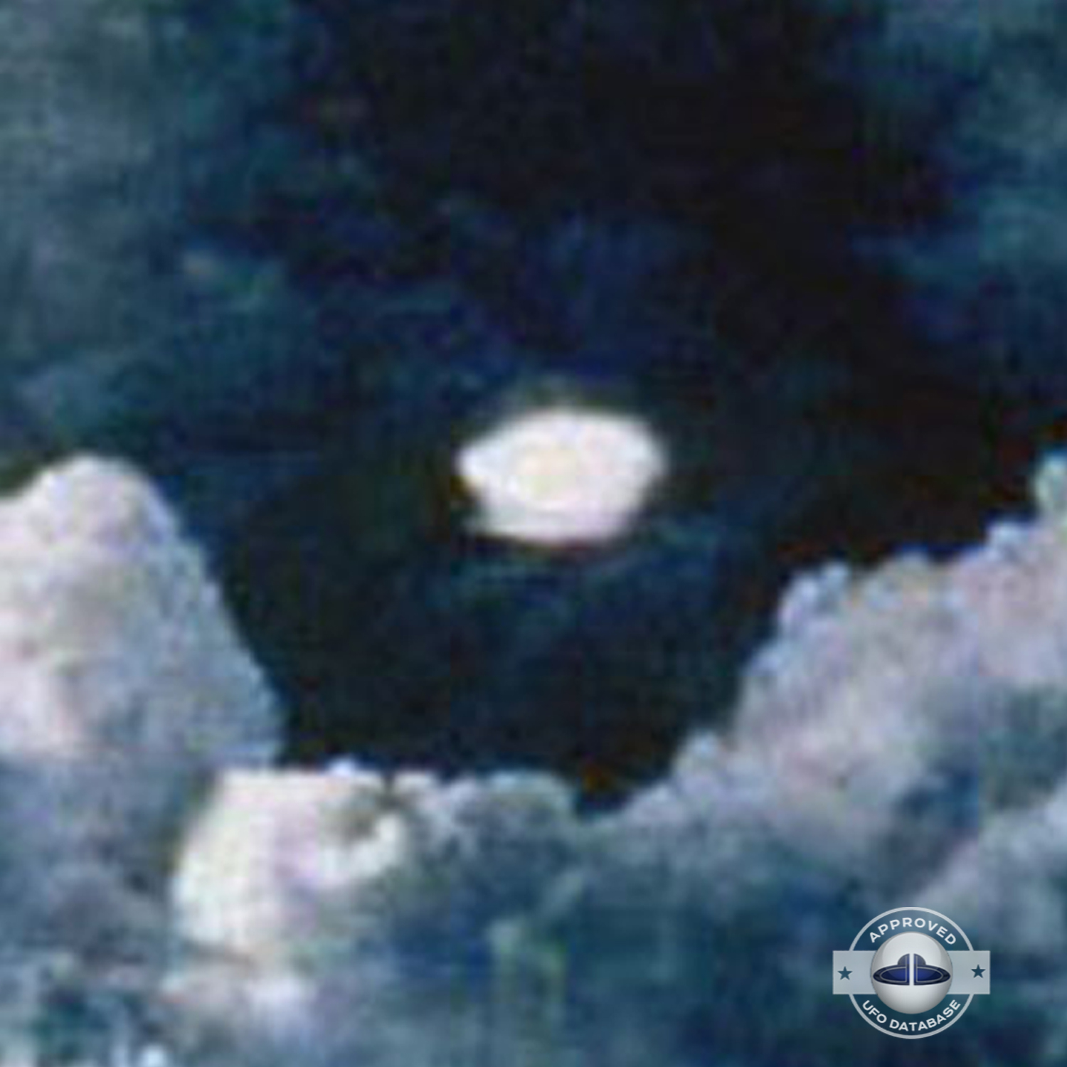 very bright disc-like object remaining stationary near a thunderhead UFO Picture #102-4