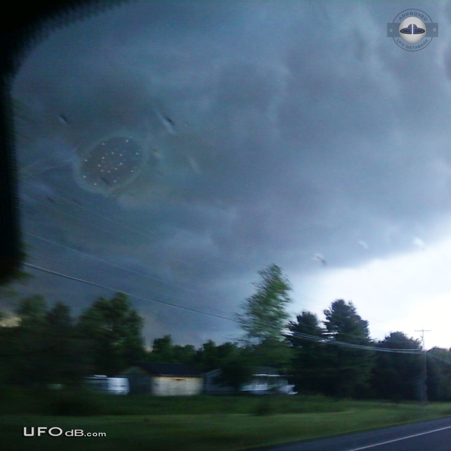 Large saucer ufo appears through dark stormy clouds - Malone, New York UFO Picture #414-1