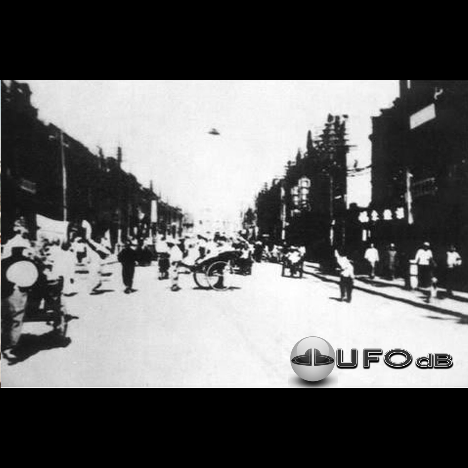 Black and white UFO picture showing UFO flying over busy street UFO Picture #43-1