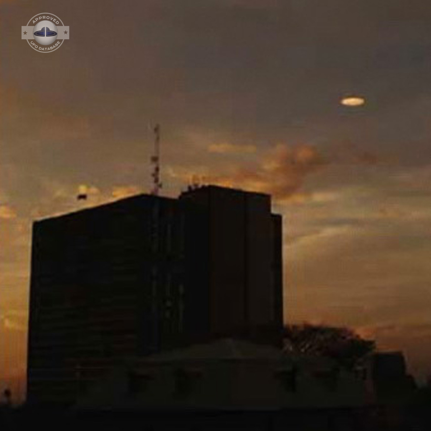 UFO picture showing a bright flat round disc passing near a building UFO Picture #54-2