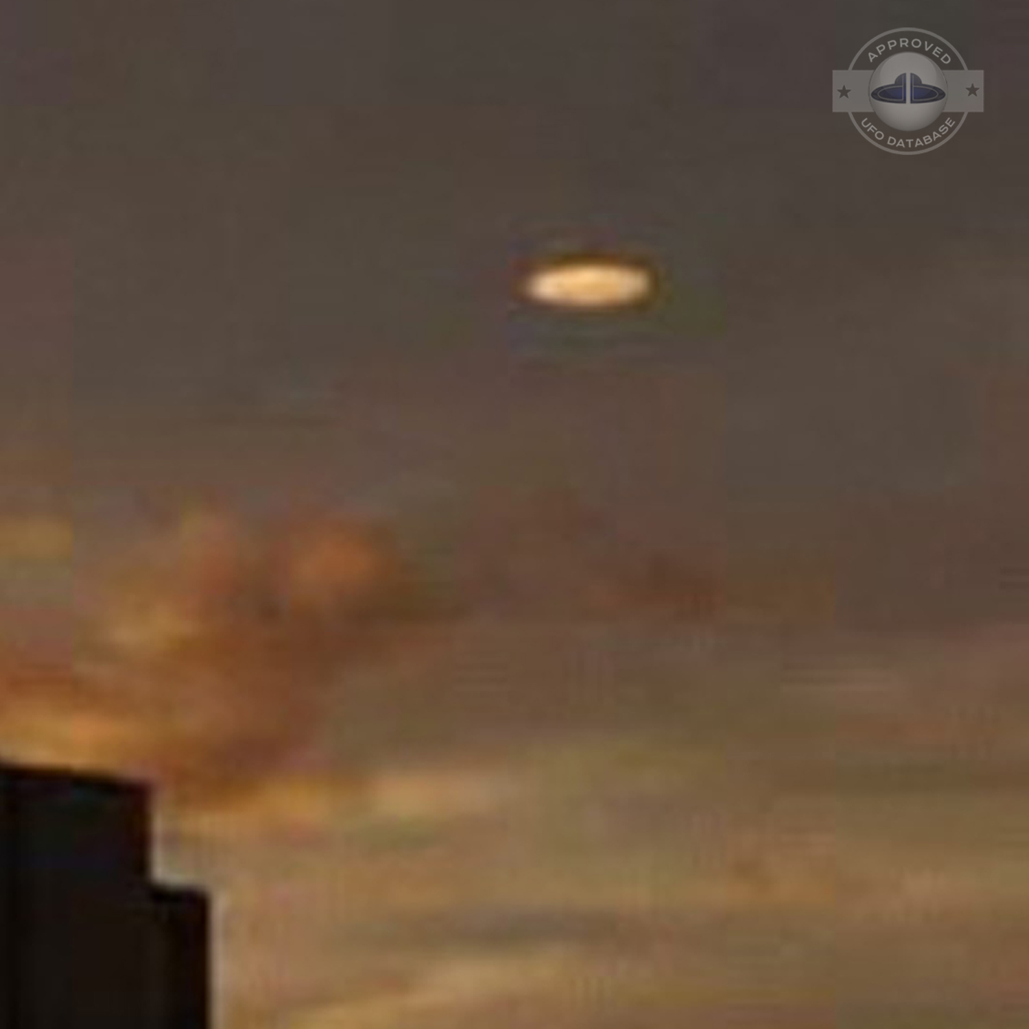 UFO picture showing a bright flat round disc passing near a building UFO Picture #54-4