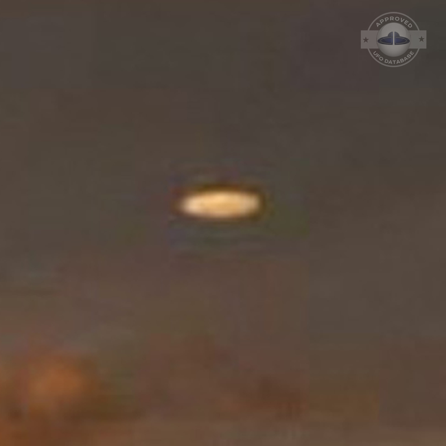 UFO picture showing a bright flat round disc passing near a building UFO Picture #54-5