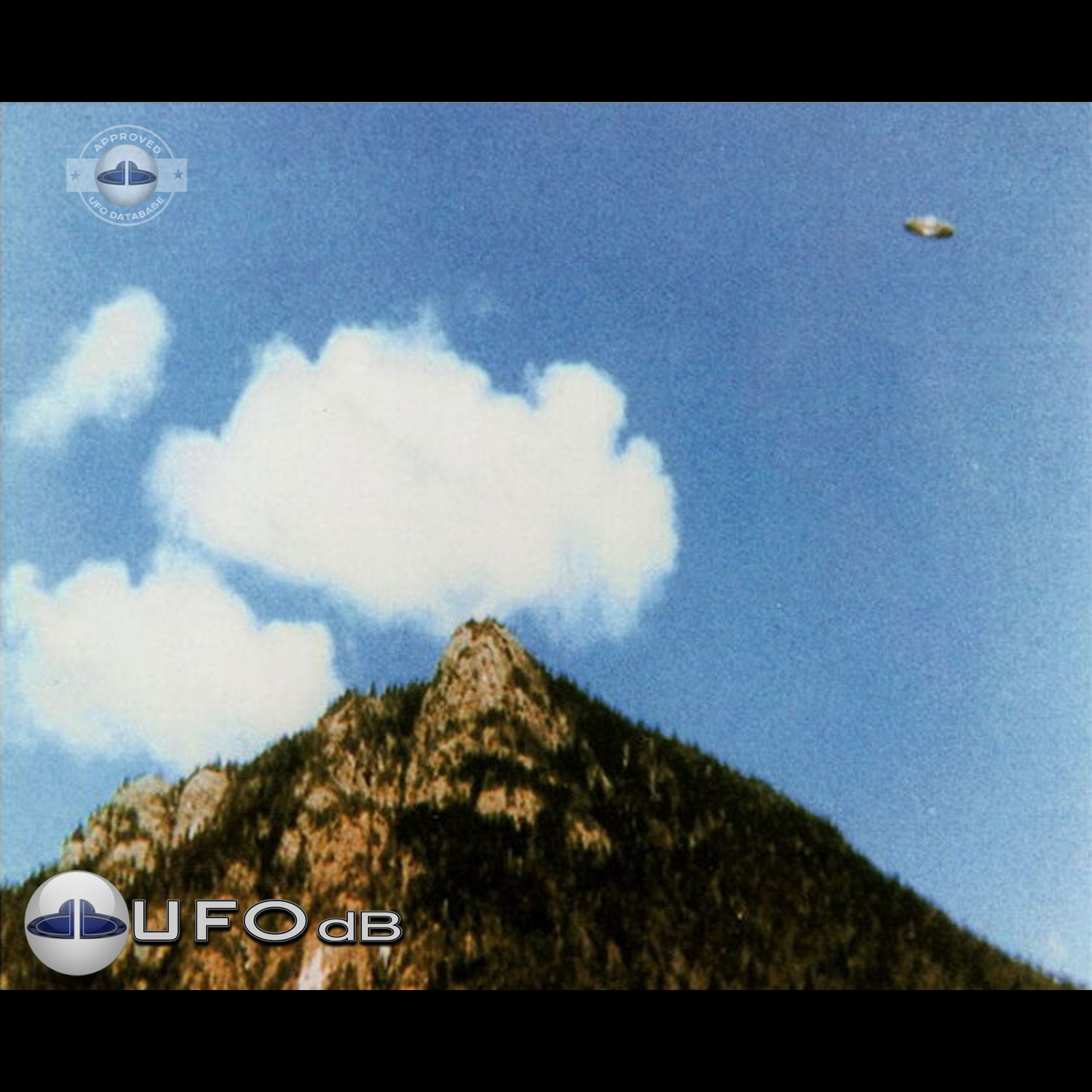 We can see a Saturn shaped UFO flying over a mountain top UFO Picture #57-1