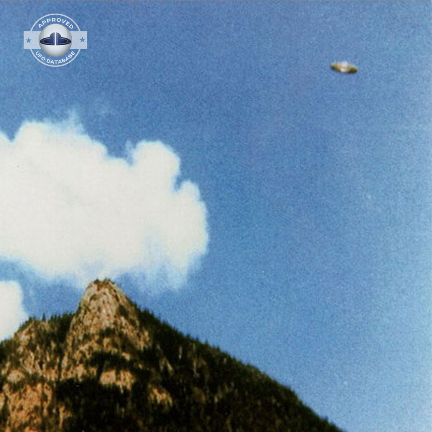 We can see a Saturn shaped UFO flying over a mountain top UFO Picture #57-2