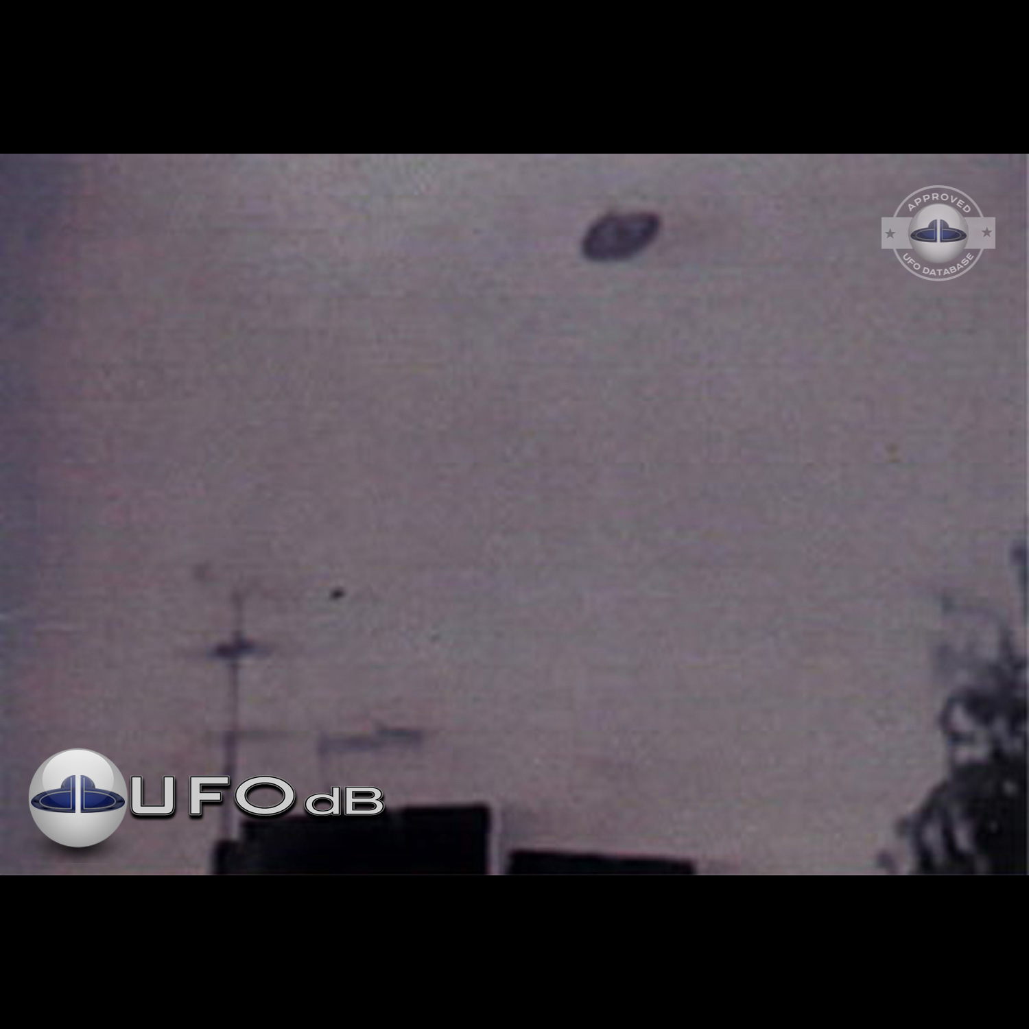 Unidentified flying object is flying over a building with antennas UFO Picture #59-1