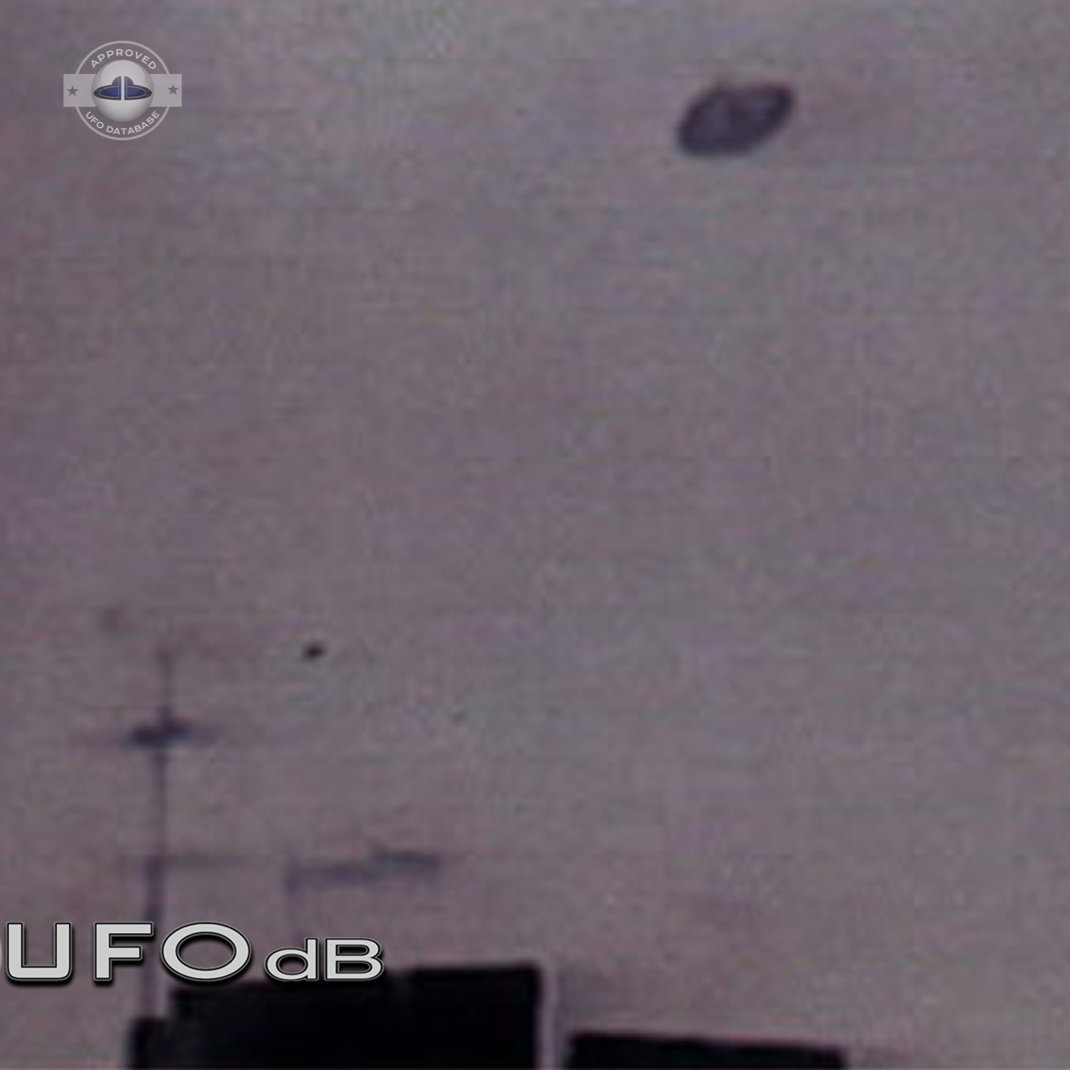 Unidentified flying object is flying over a building with antennas UFO Picture #59-2