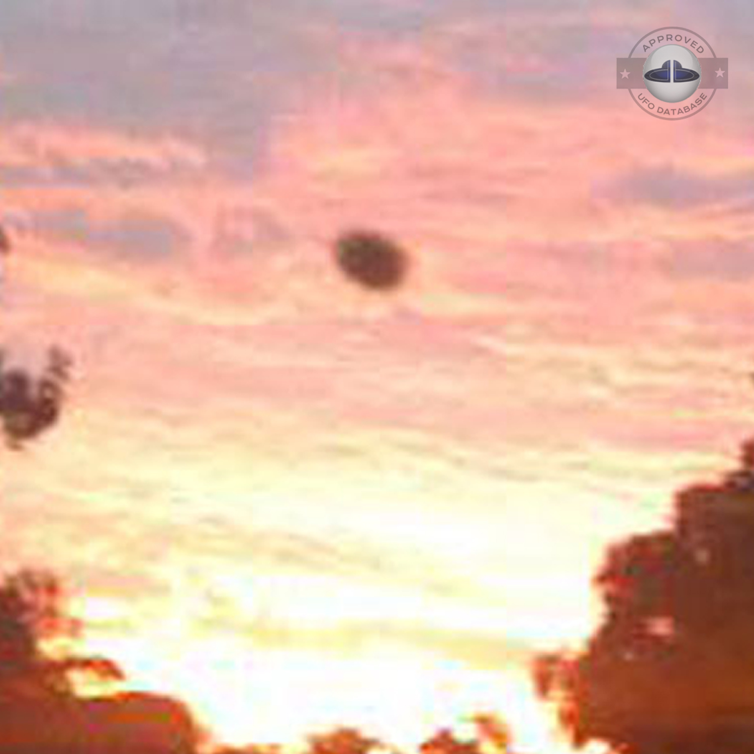 The UFO came out from a light in the cloudy sky during sunset UFO Picture #76-4